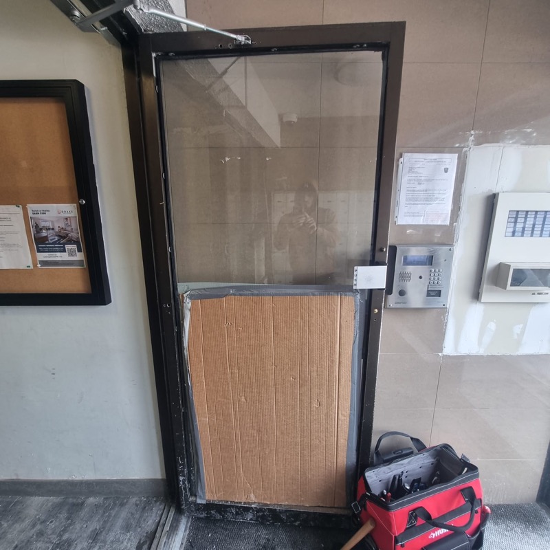 Broken door glass with temporary fix before repair