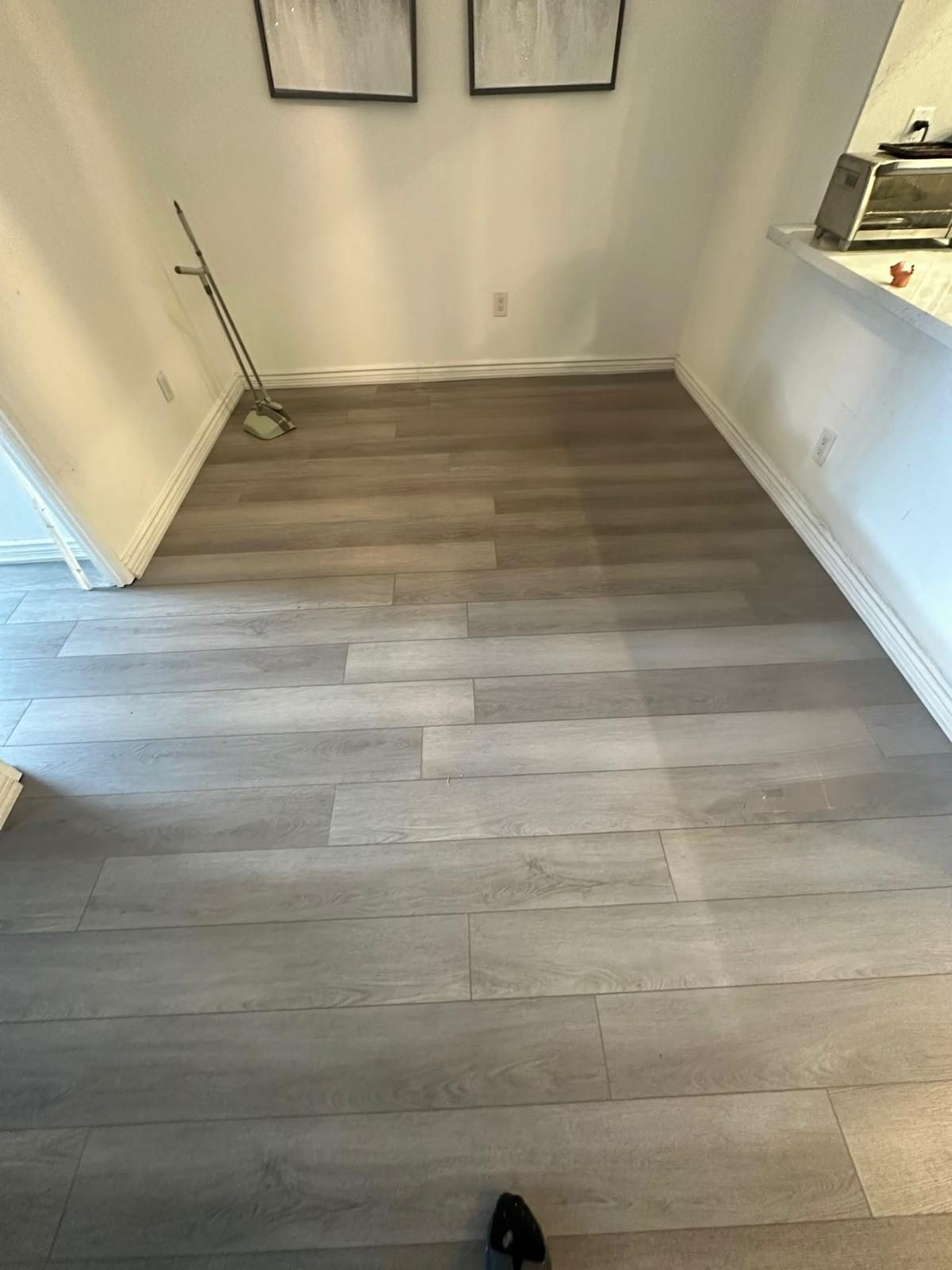 Grey wood-look vinyl plank flooring installed in an empty condo living room in Toronto
