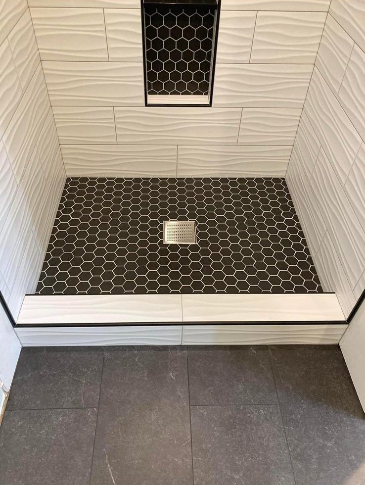 Black hexagon mosaic shower floor and matching recessed niche with white textured wall tile, GTA bathroom renovation