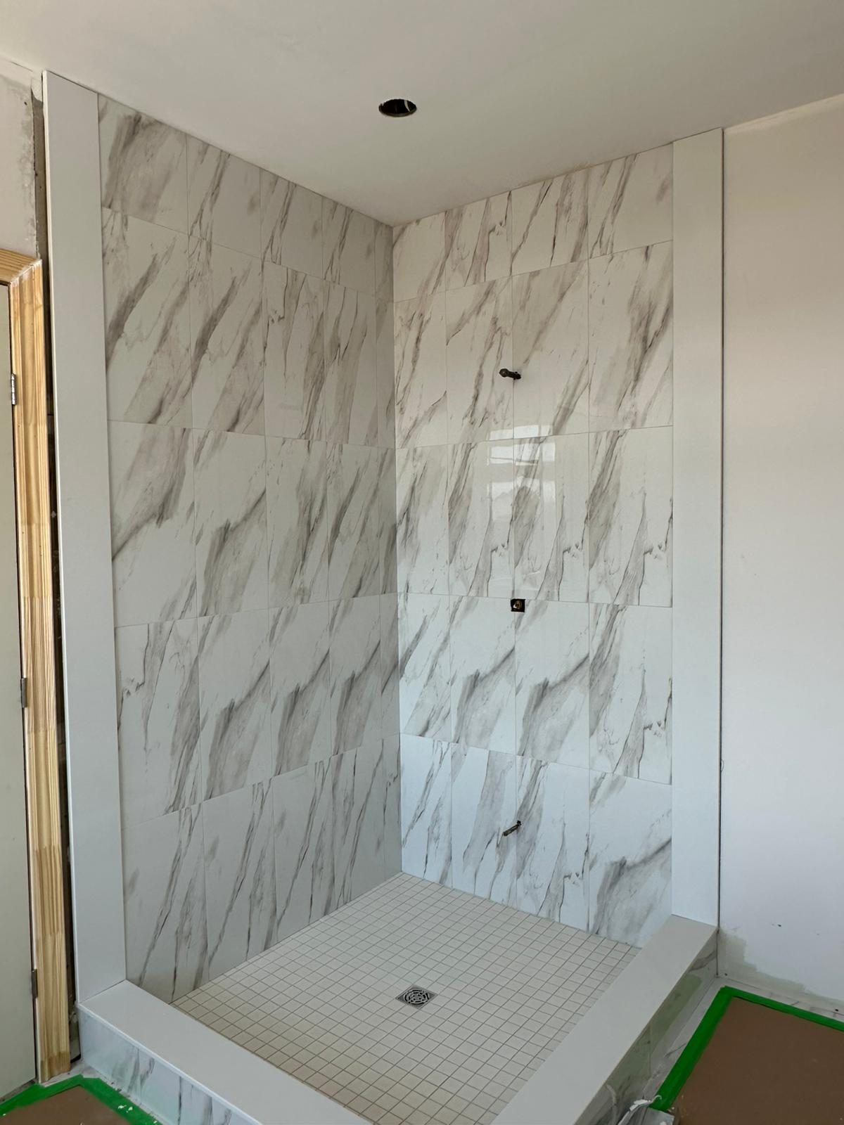 Walk-in shower with floor-to-ceiling marble-look porcelain wall tile and a white mosaic shower floor, GTA bathroom renovation